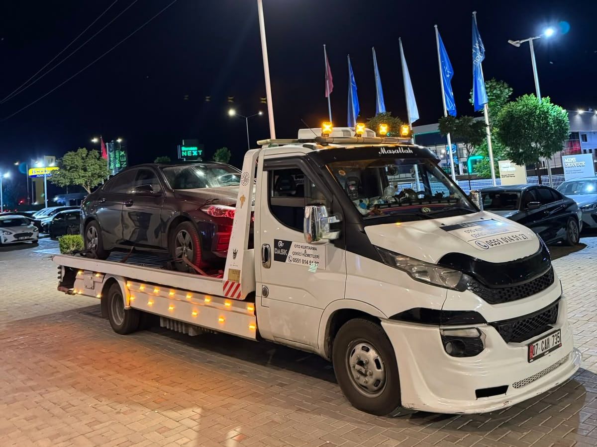 Gece ikaz lambaları yanan çekici üzerinde koyu renk otomobil