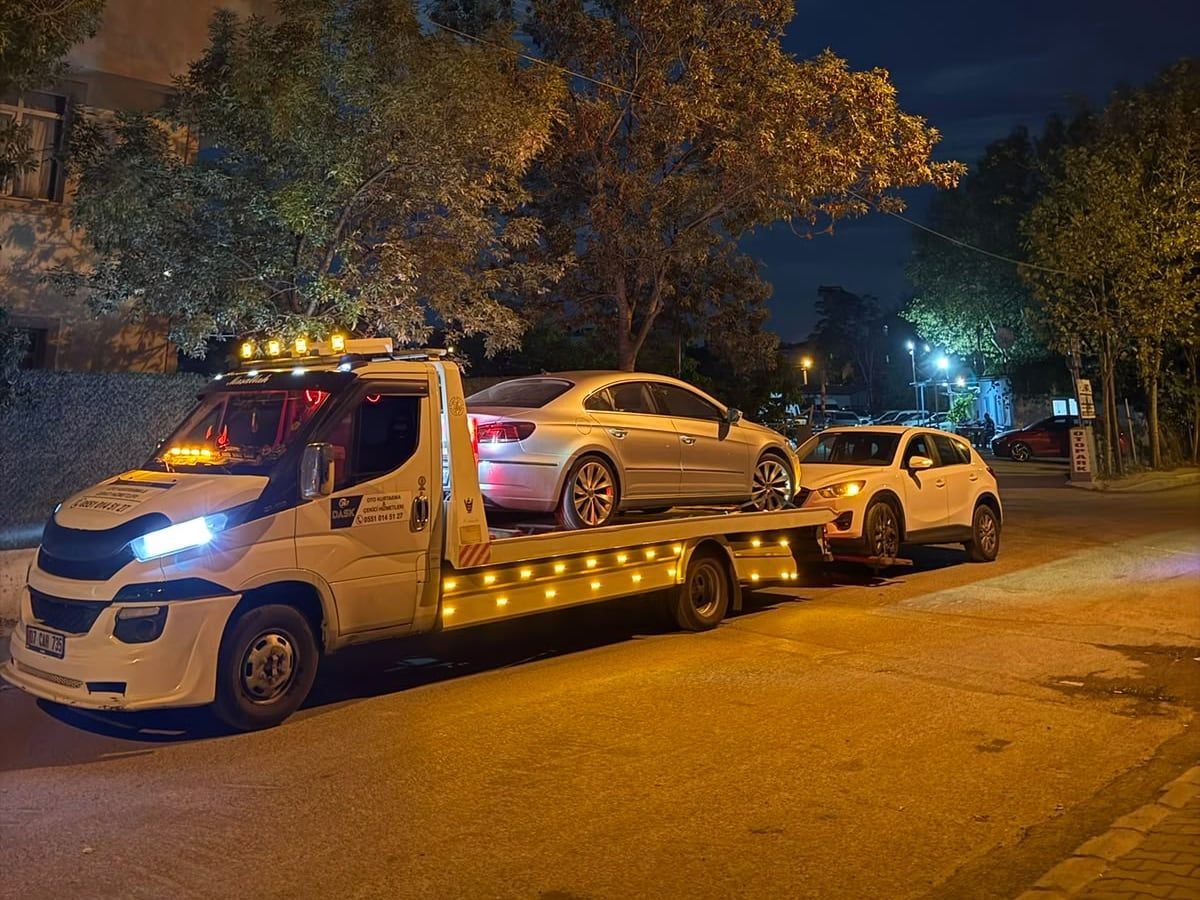 Gece şehir içinde iki aracı taşıyan çekici